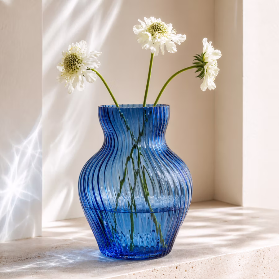 Große gerippte blaue Glasvase mit weißen Blüten